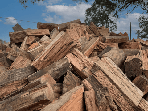 A close-up view of a stacked pile of mixed hardwood firewood ready for use.